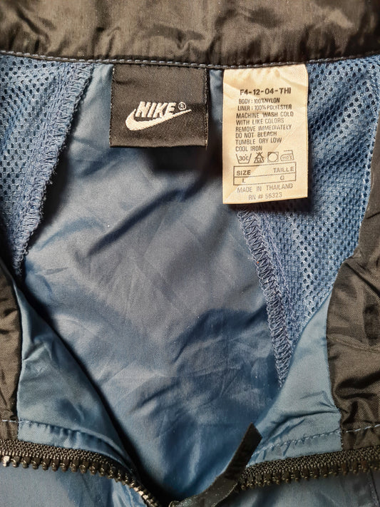 Innenetikett mit Nike-Logo und Pflegehinweisen des Windbreakers (Größe L, Made in Thailand).