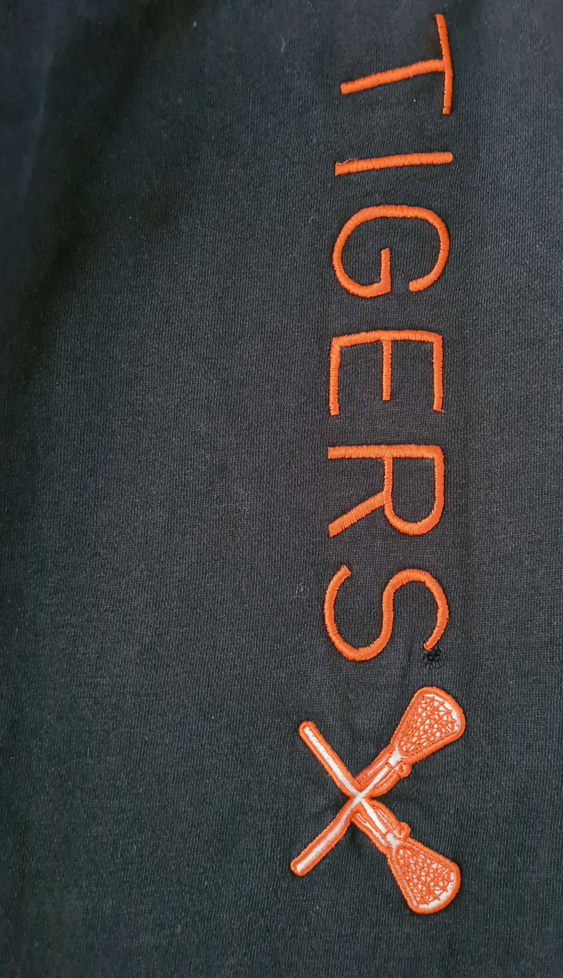 Detailansicht TIGERS-Stickerei mit kleinem Loch am Ärmel