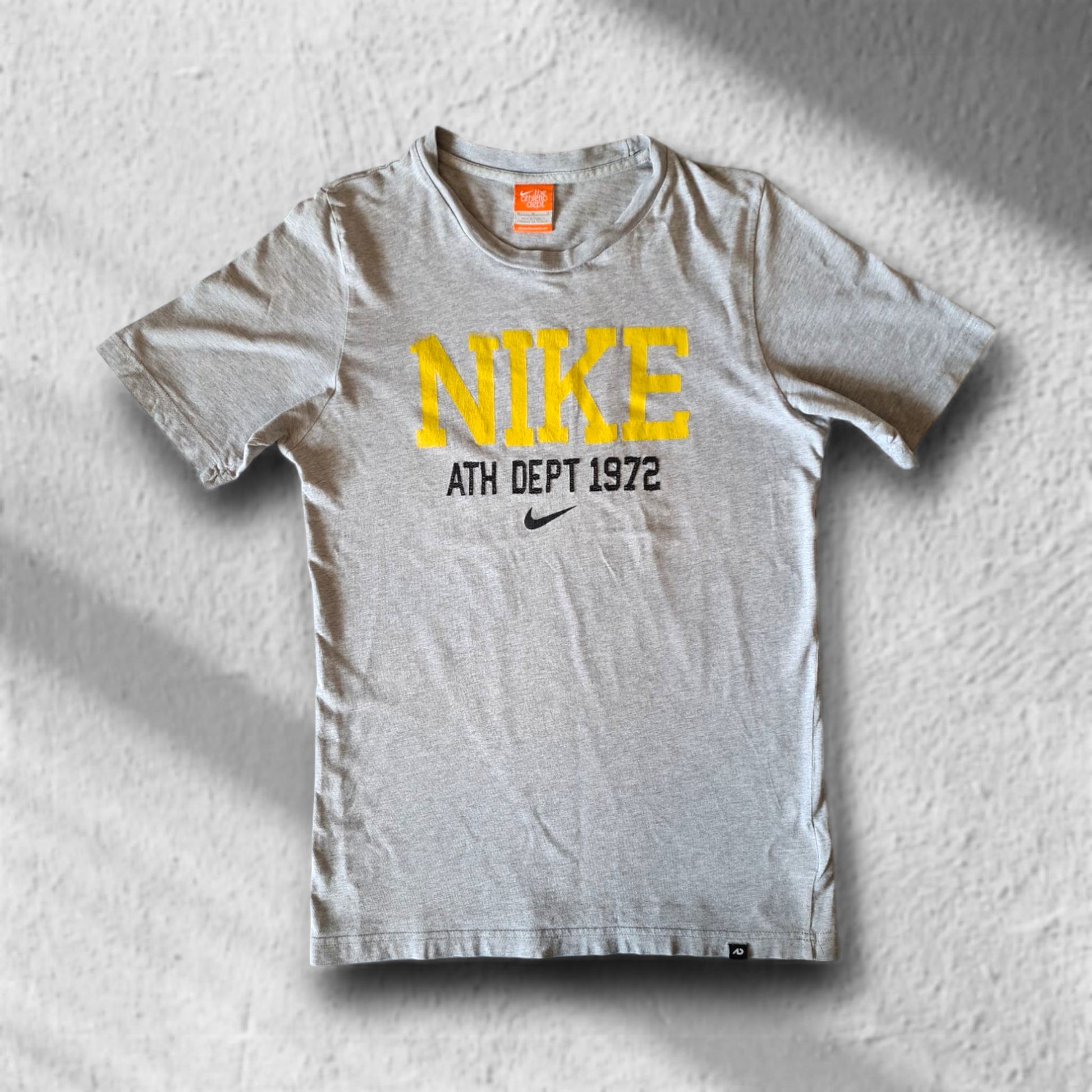 Nike T-Shirt in Grau mit gelbem „ATH DEPT 1972“-Print, Größe M – Vorderseite