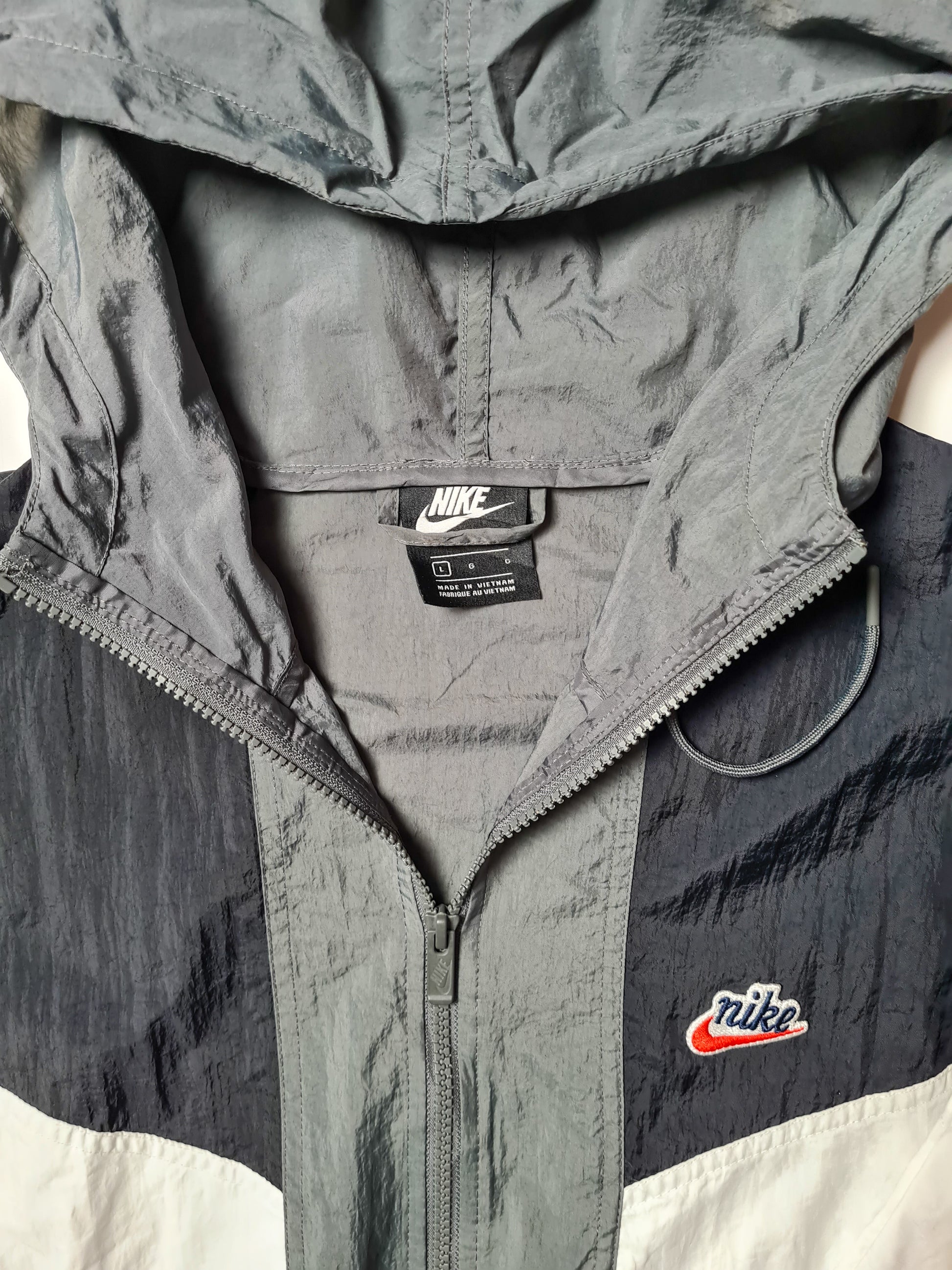 Innenansicht mit Nike-Label und gesticktem Logo. Detailaufnahme vom gestickten roten Swoosh auf der Brust.